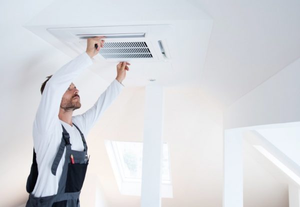 a man cleaning an air duct