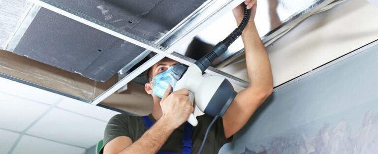 a man doing maintenance on an air duct