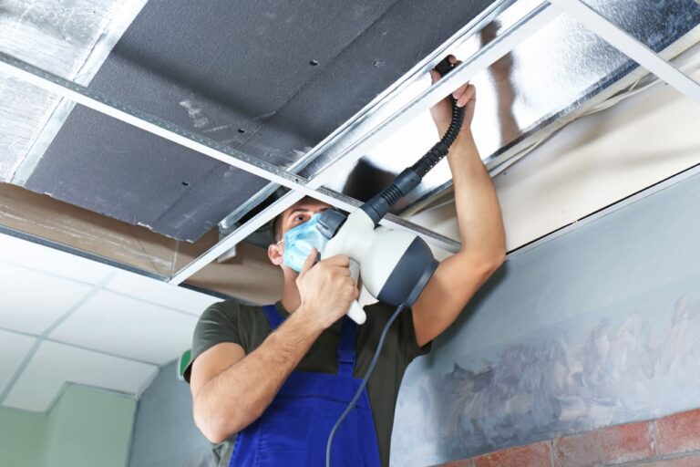 a man doing maintenance on an air duct